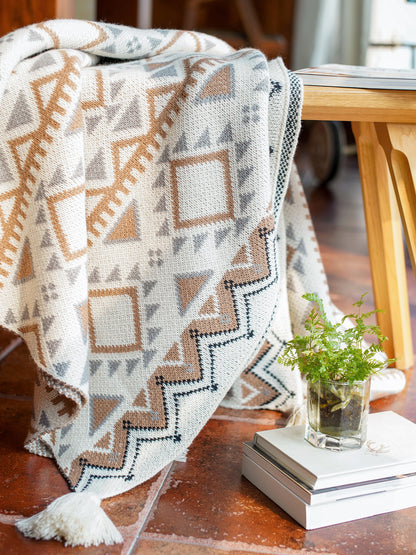 knitted acrylic boho throw blanket over a wooden table