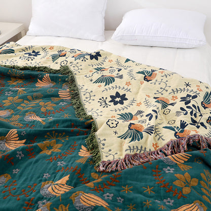 Floral-patterned blankets draped over a bed with white pillows.