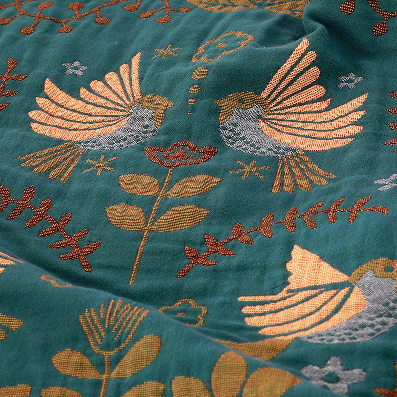 jacquard fabric with birds and floral patterns on a teal background