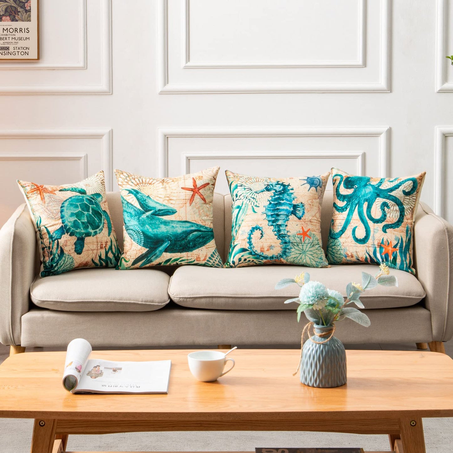 Sofa with decorative pillows featuring sea creatures, a coffee table with a cup and magazine in a living room setting.